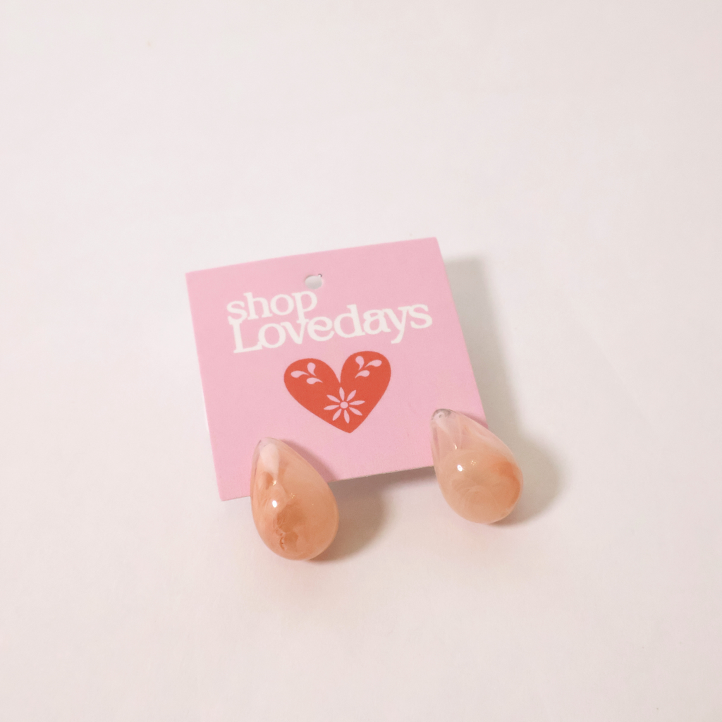 peachy pink teardrop earrings on a product tag shown on a white backdrop