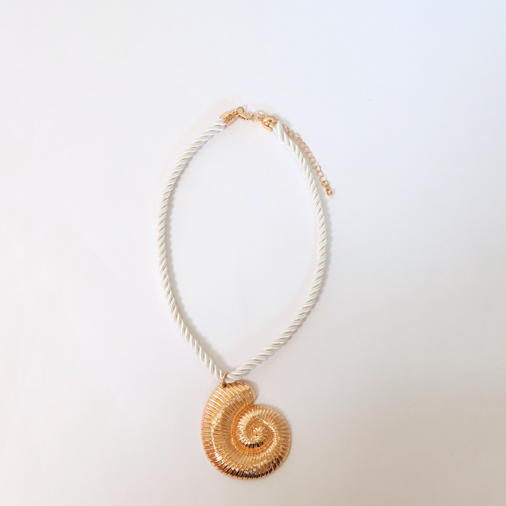 cream rope and brassy metal necklace with metal shell pendant displayed on a white background