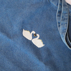 close up photo of embroidered swans on tote bag