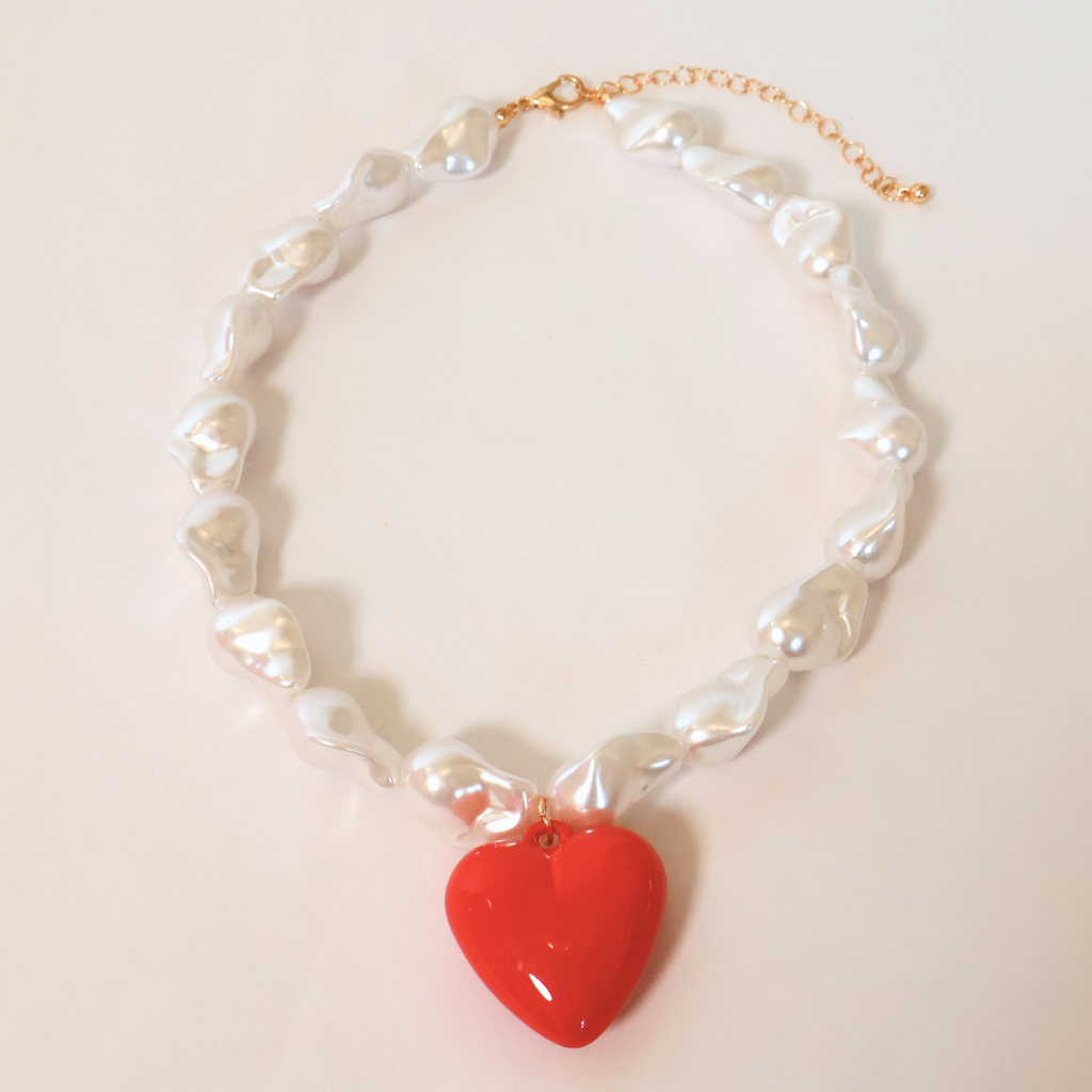 faux baroque pearl necklace with a red heart pendant on a white background