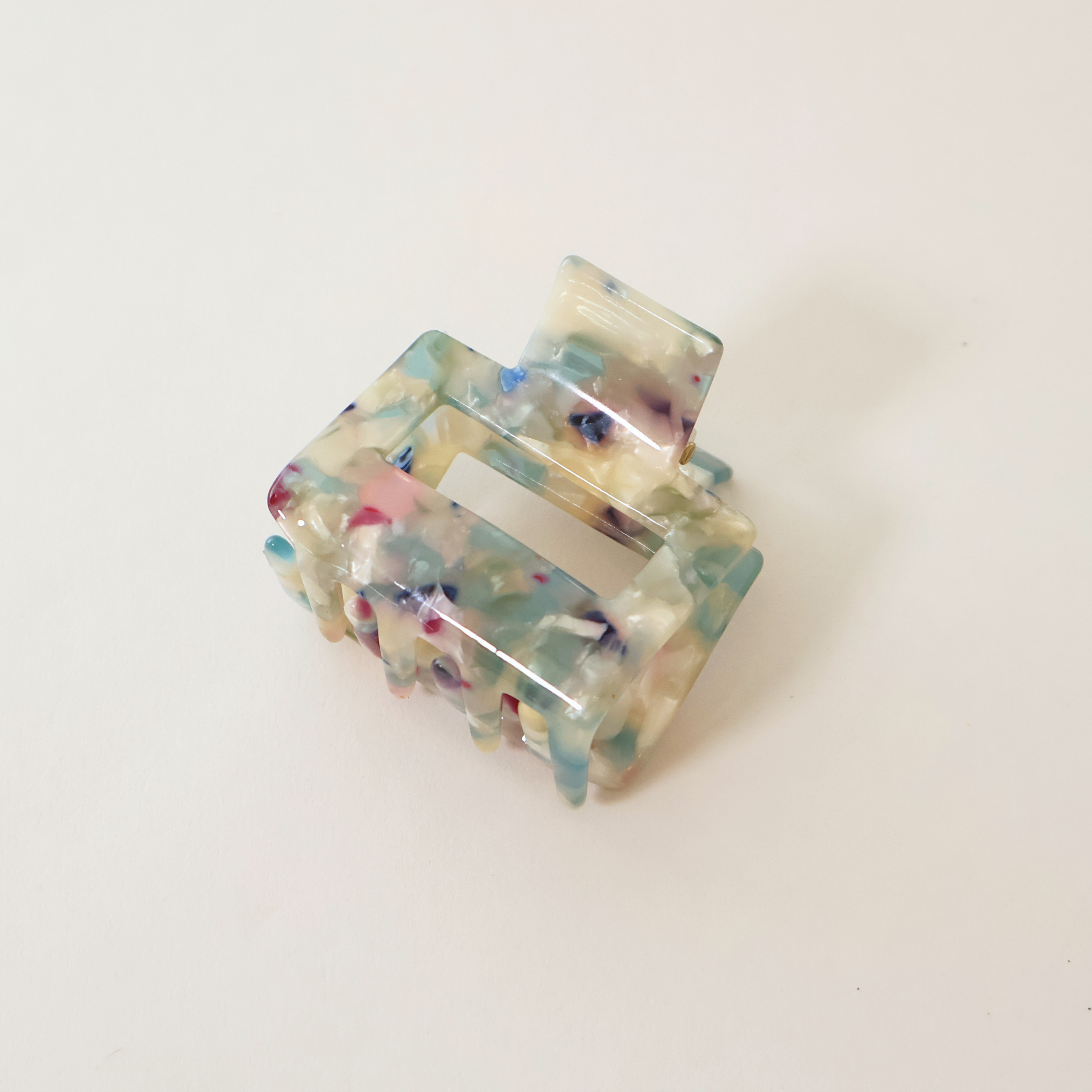 side view Blue multi colored marbled claw clip on white background