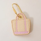 Lavender bag shaped bag charm on a white background
