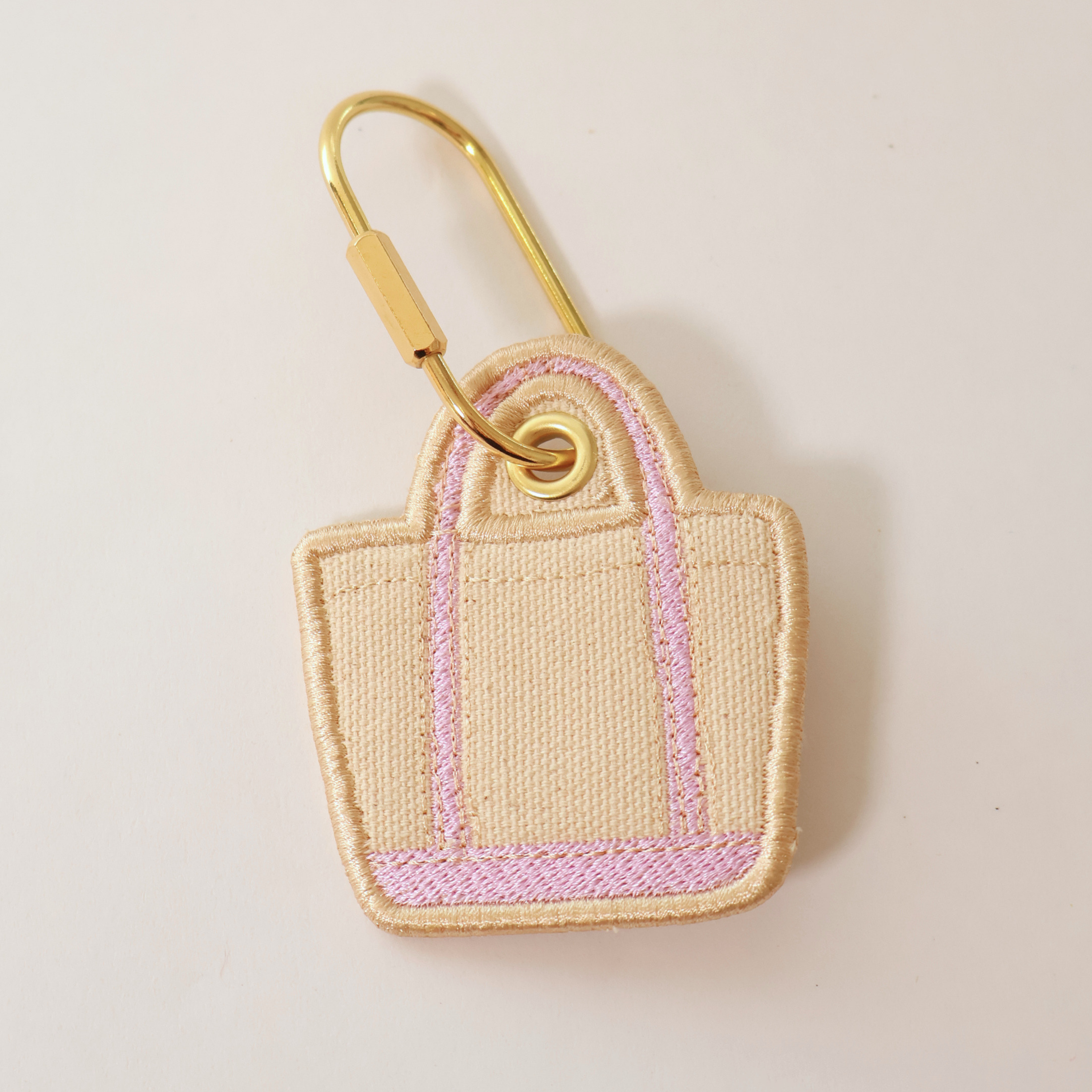 Lavender bag shaped bag charm on a white background