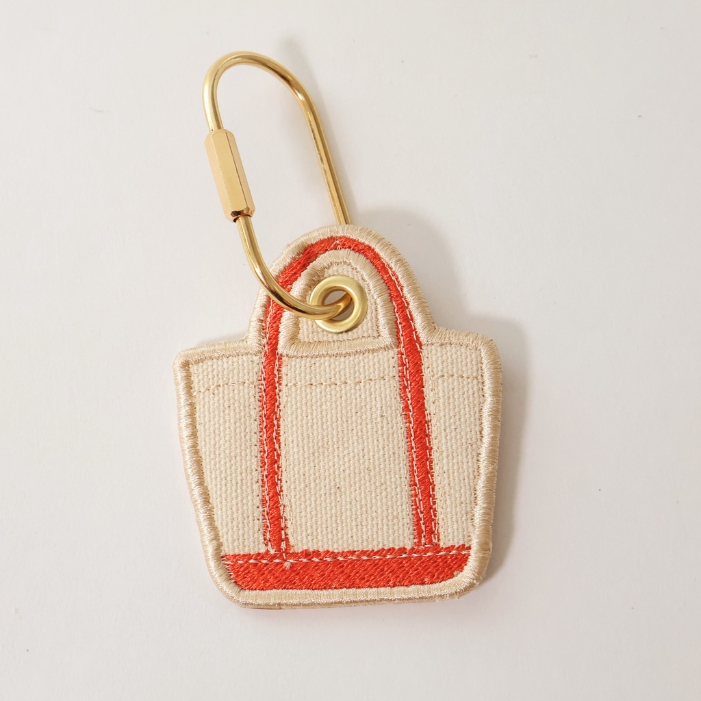 Vermillion or red bag shaped bag charm on a white background