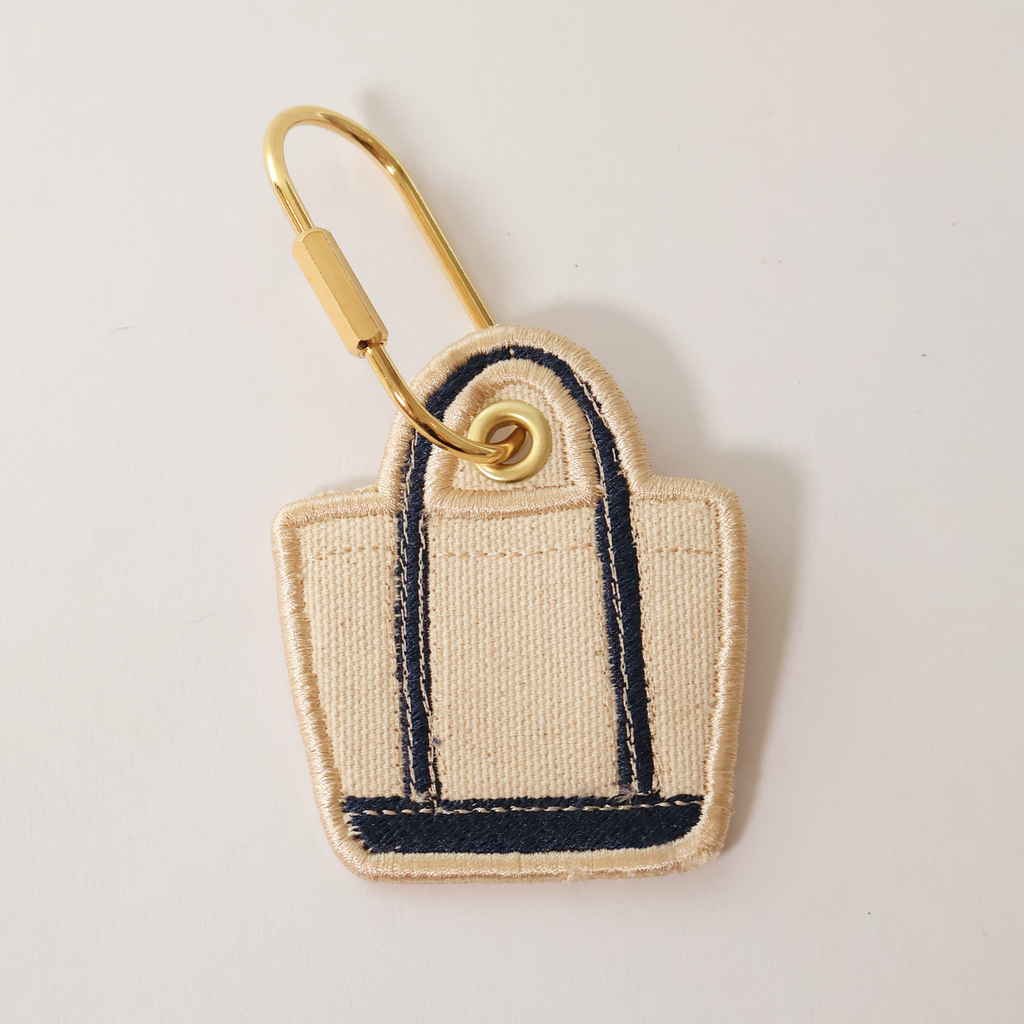 Navy Blue bag shaped bag charm on a white background