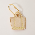 Butter yellow bag shaped bag charm on a white background