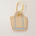 Light blue bag shaped bag charm on a white background