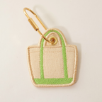 Green bag shaped bag charm on a white background