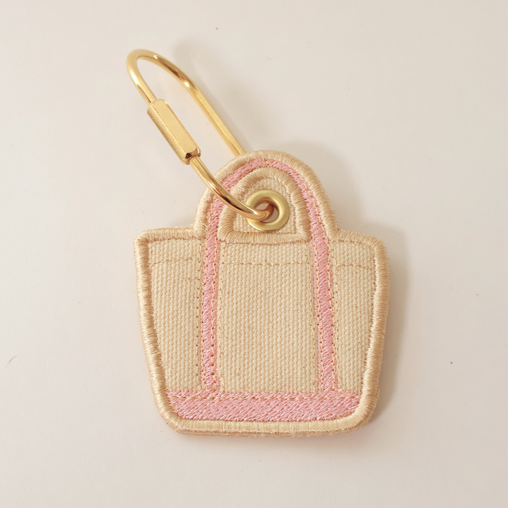 Pink bag shaped bag charm on a white background