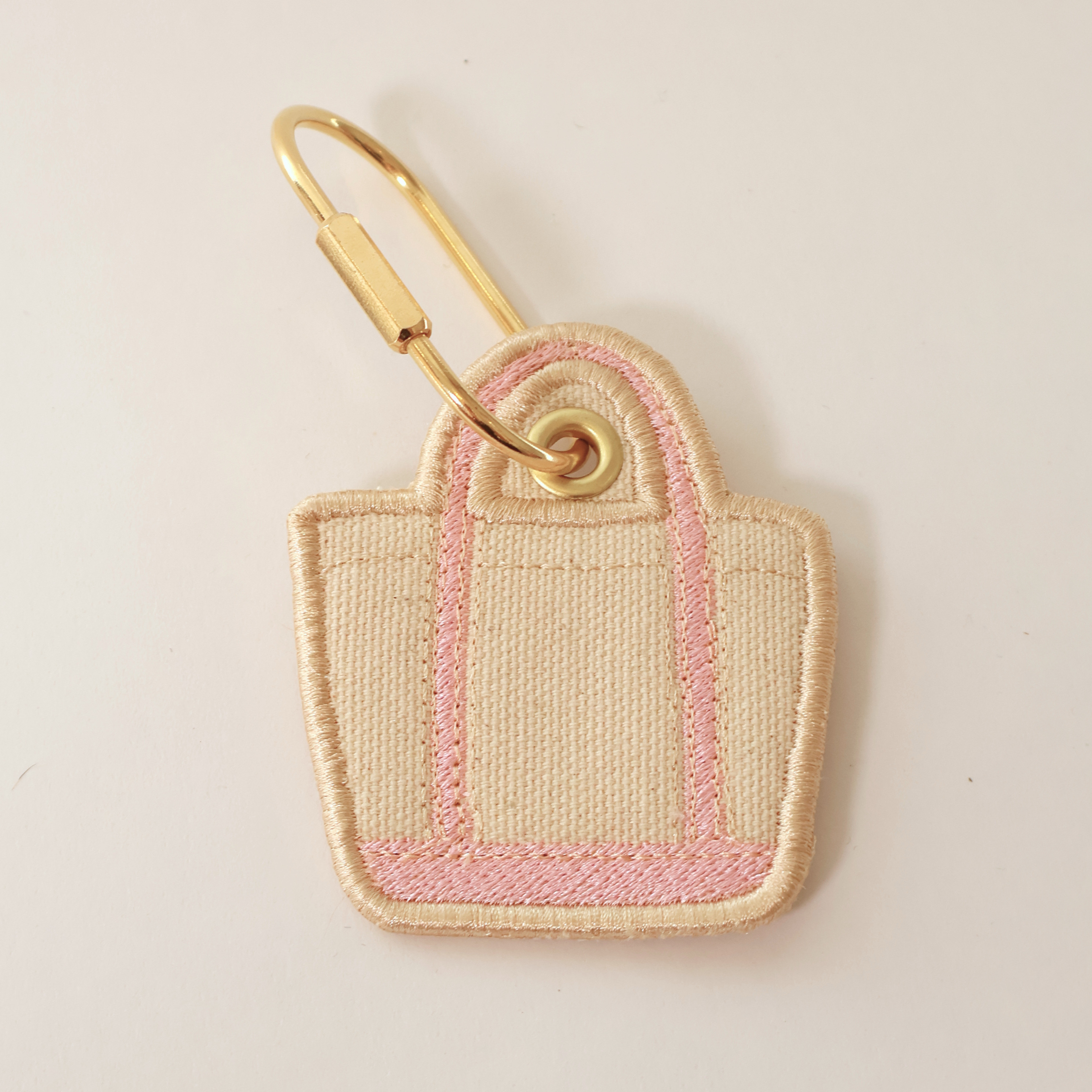 Pink bag shaped bag charm on a white background