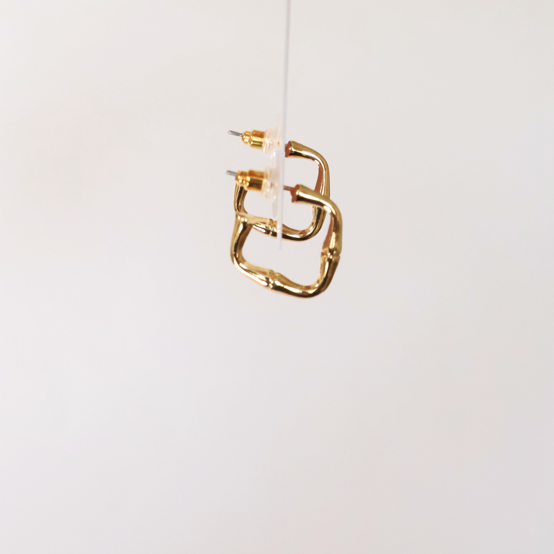 side view of earrings to show shape. displayed on a white background.