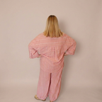 Woman facing away from the camera wearing the matching Azalea button down shirt and balloon style pants. 