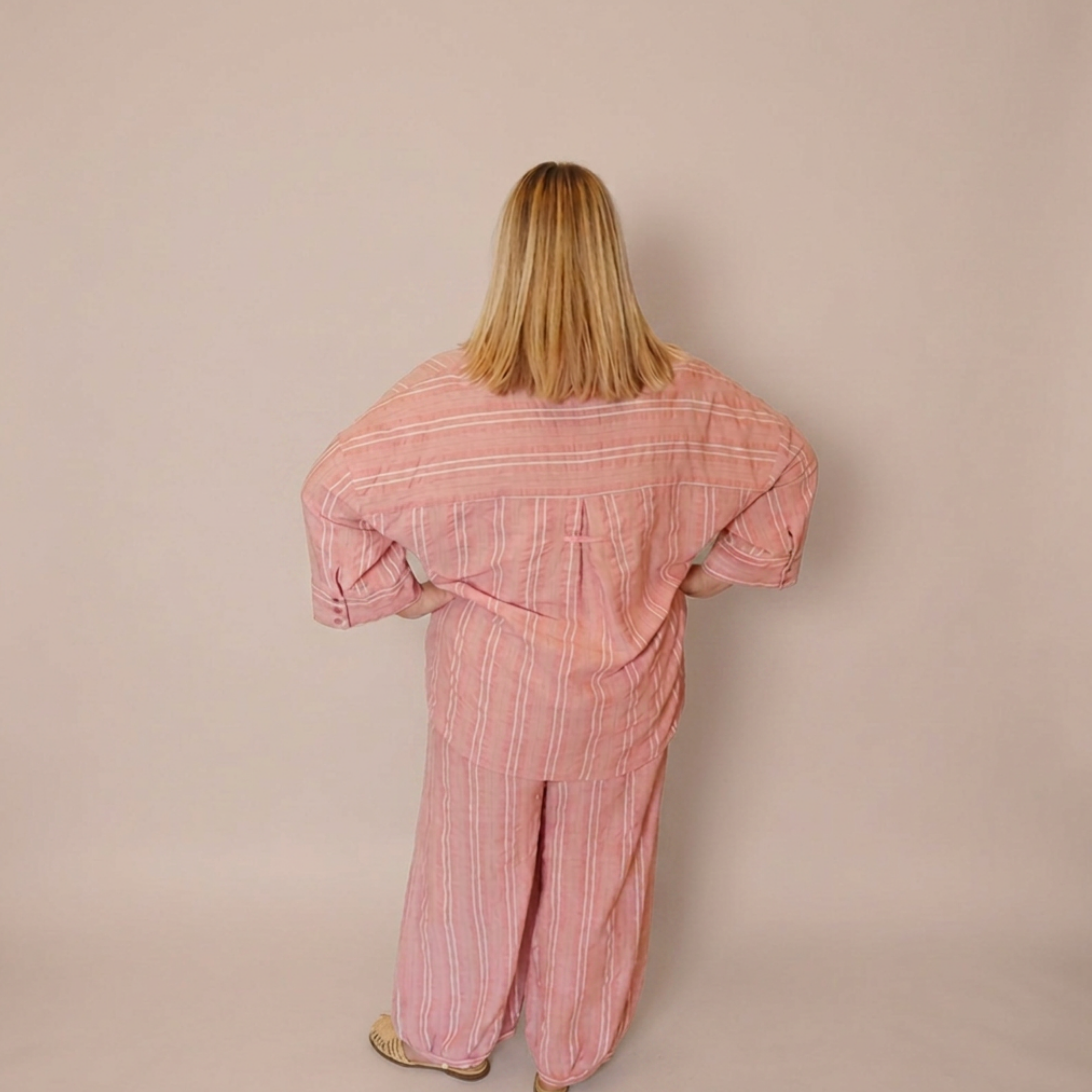 Woman facing away from the camera wearing the matching Azalea button down shirt and balloon style pants. 