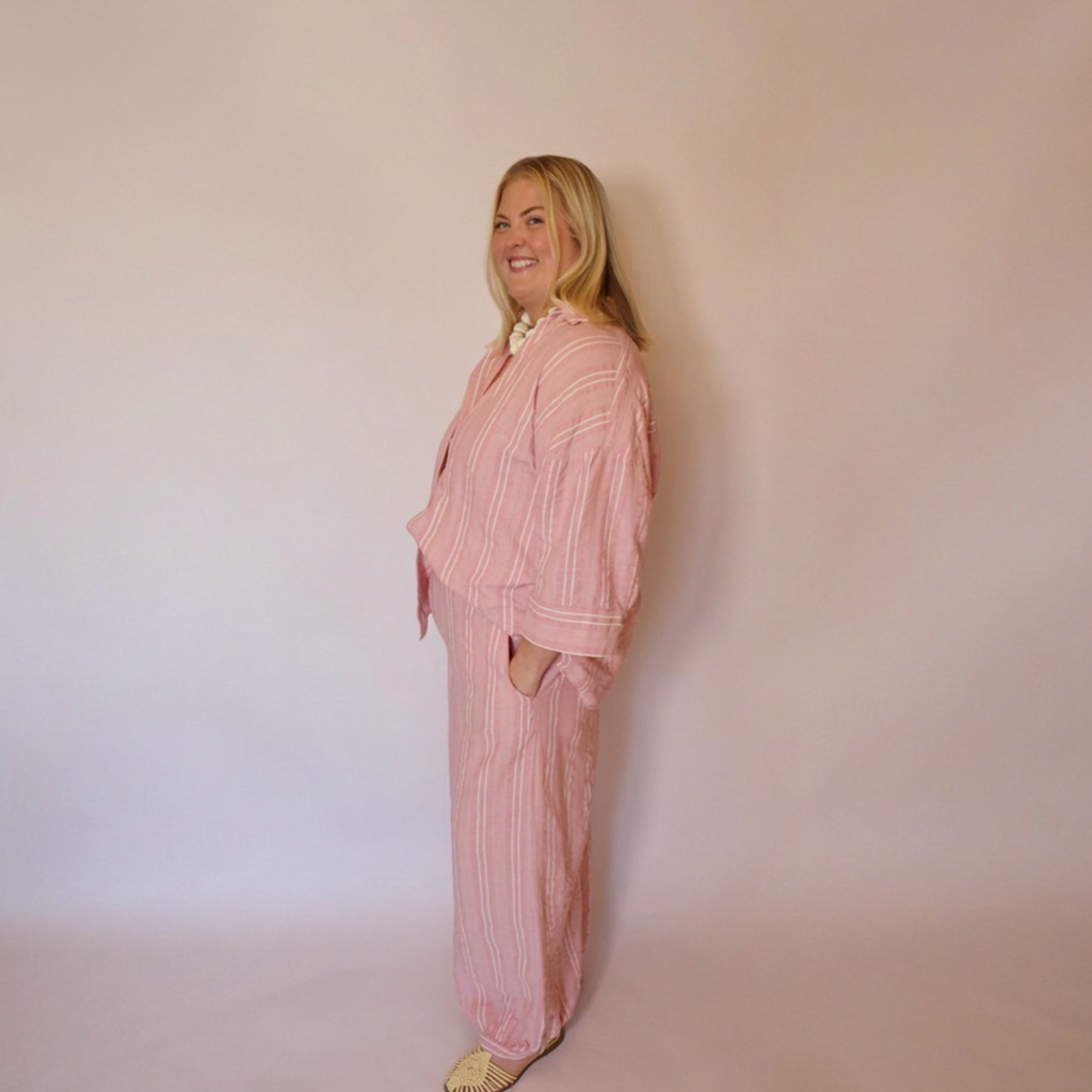 Woman facing to the left wearing the matching Azalea button down shirt and balloon style pants. 