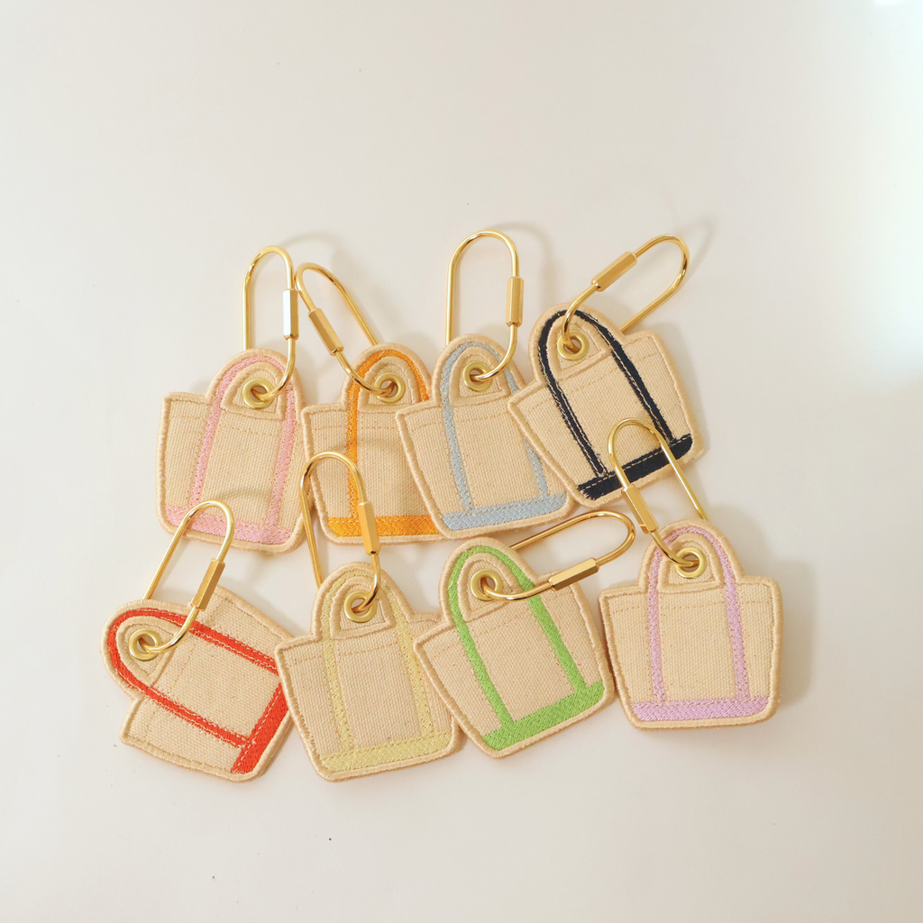 all 8 colors of our Elise Bag Charms shown on a white background