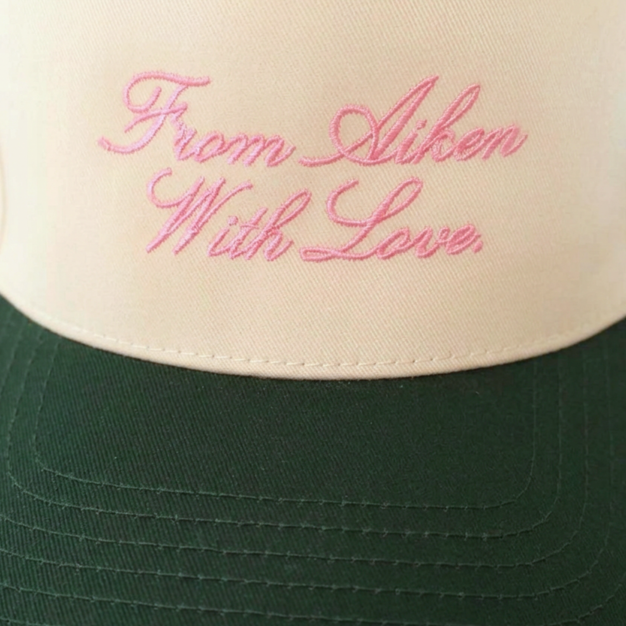 Close view of embroidery on hat that says "From Aiken With Love."