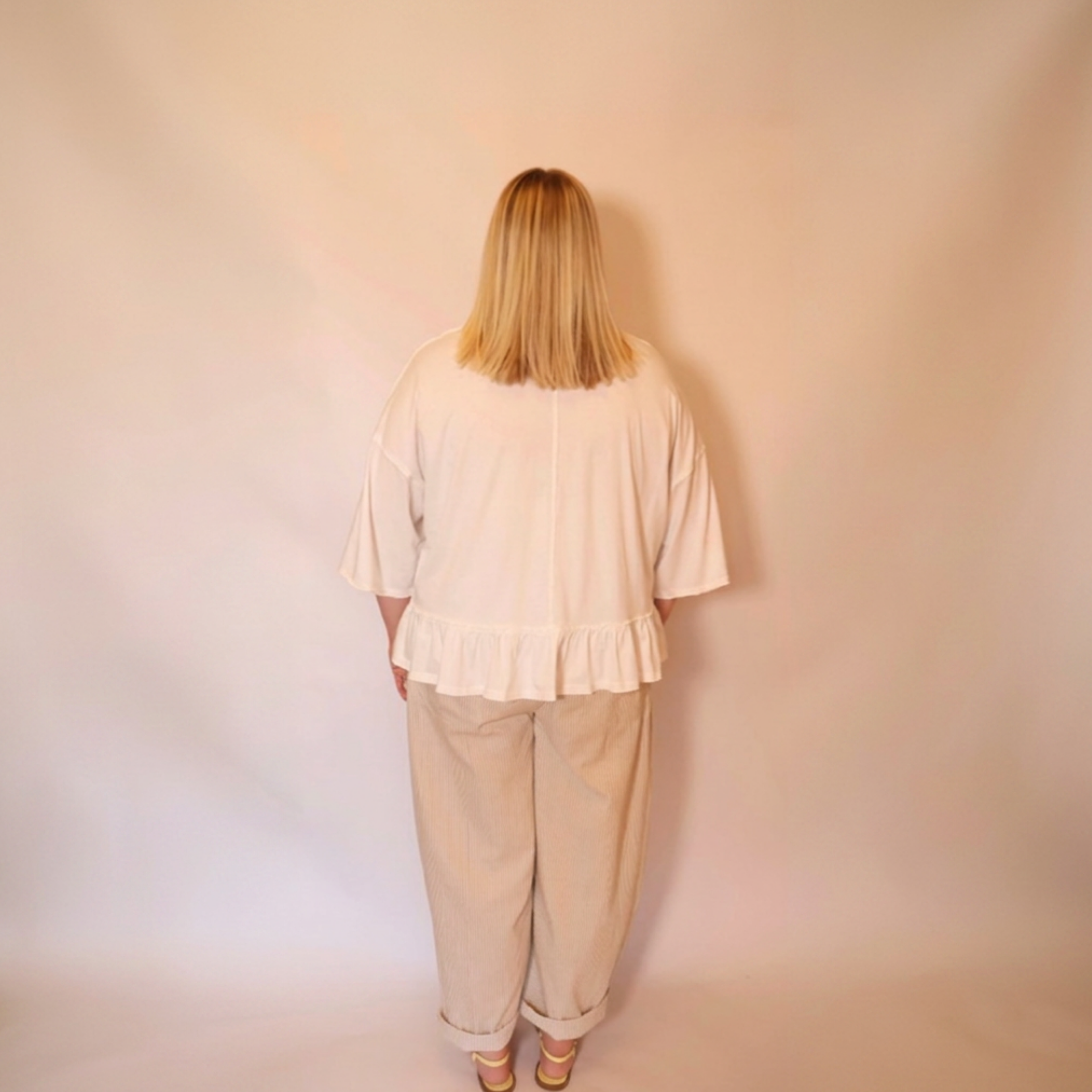 Woman facing backwards wearing the white willa tee and the hollis pants