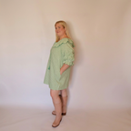 Woman facing left wearing the Green Gingham Louisa Dress and pink boots.
