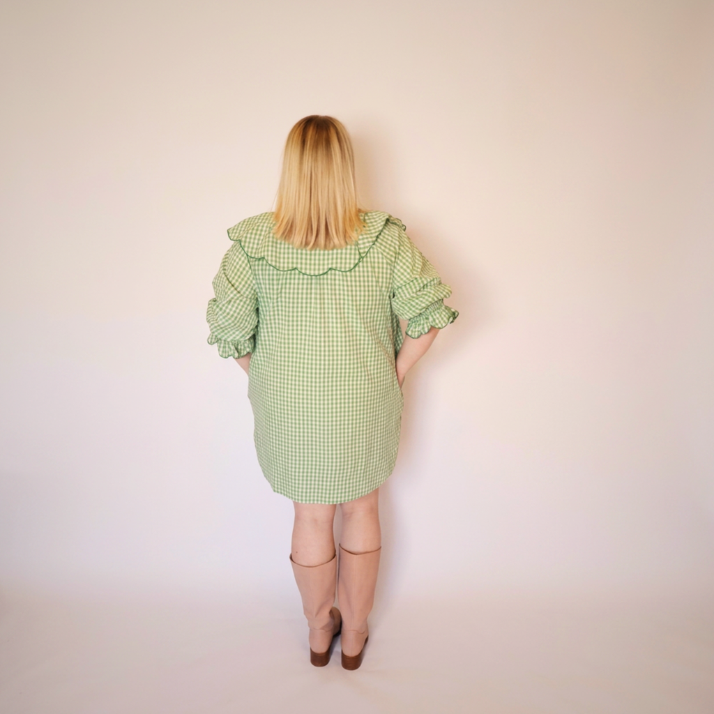 Woman facing backwards wearing the Green Gingham Louisa Dress and pink boots.