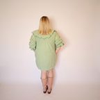 Woman facing backwards wearing the Green Gingham Louisa Dress and pink boots.